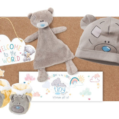 Baby gift set with teddy bear hat, comfort blanket, and booties in a box.
